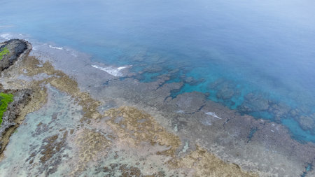 Sea surface in Okinawa with clear water and rock from aerial view by drone.の写真素材