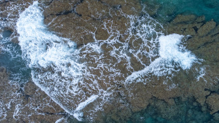 Sea surface in Okinawa with clear water and rock from aerial view by drone.
