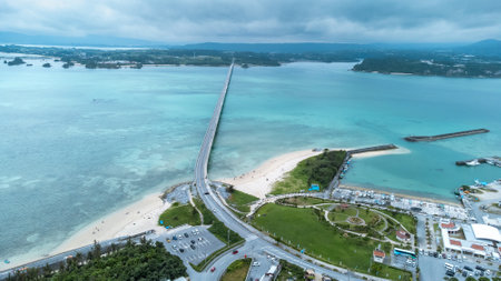 Long bridge of Kouri Island and beach from high view by drone with clear sky and sea water.の写真素材