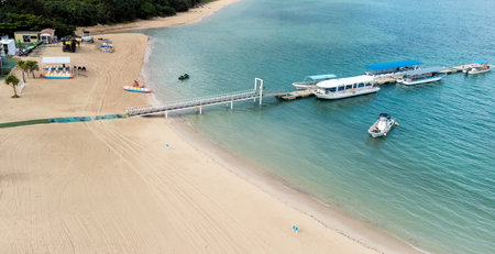 The serene seascape of Okinawa showcases crystal-clear waters, exposed rocky formations, and gentle...