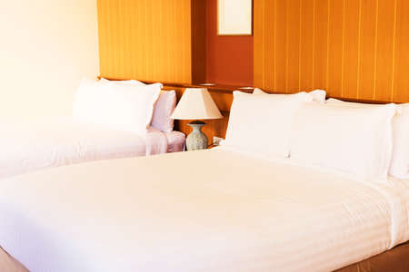 White clean comfortable pillow on two bed decoration interior of hotel bedroom of brown background - Hotel bed with space for text and beautifulの写真素材