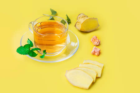Ginger ale in glass with ginger slice on yellow background - Healthcare herb and spiceの写真素材