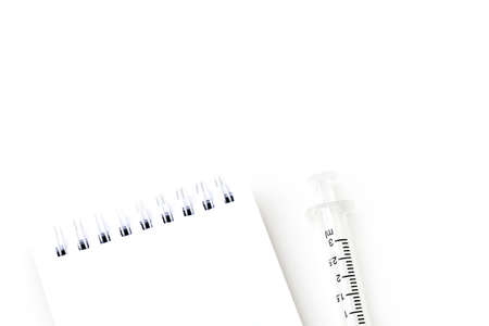Blank notebook page paper with a syringe flat lay minimal background - Concept Healthcare and Medicalの写真素材