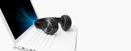 Wireless headphones on white laptop - Banner Headset, hotline support concept in office background
