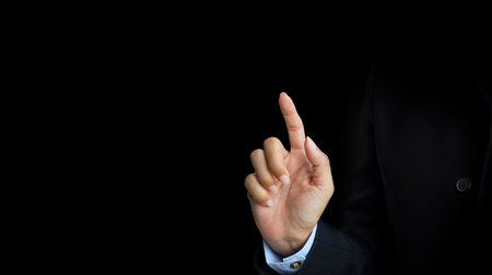 Businessman hand pushing button on a touch screen interface isolated on black backgroundの写真素材