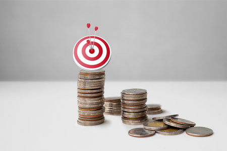 Dartboard on the top of coins stacking with up arrow. Target goal aim strategy success business on coins stacked. Financial investment conceptの写真素材