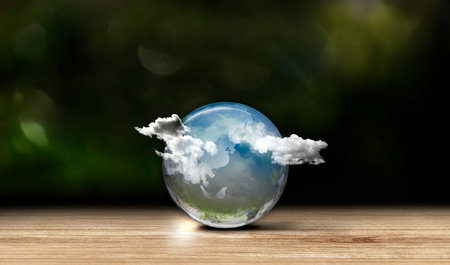 Crystal Globe on wood table at green background. Energy saving concept