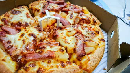 Delicious Hawaiian pizza in a cardboard box.;の写真素材