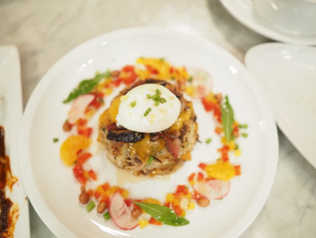 Fried rice with poached egg and vegetables in white plate.の写真素材