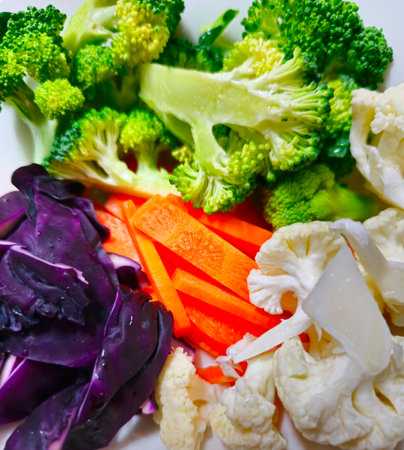 Cauliflower, carrots, broccoli and cabbage on a white plateの写真素材