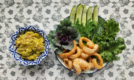 A beautifully arranged plate features crisp cucumber, leafy greens, and a flavorful side dish, creating a vibrant and healthy meal option.の写真素材