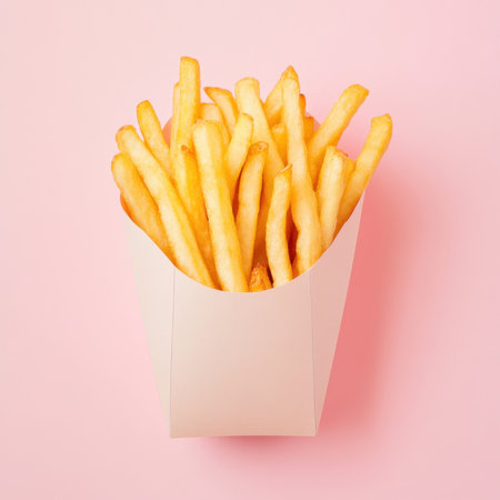 A stylish presentation of freshly cooked golden French fries in a minimalist paper container against...