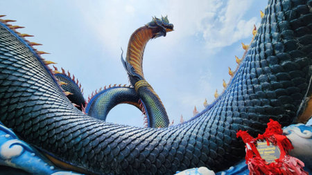 This stunning dragon sculpture showcases intricate details and vibrant colors against a clear blue sky, embodying cultural heritage and artistic creativity.の写真素材