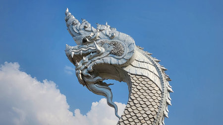 A stunning silver serpent sculpture rises against a clear blue sky, showcasing intricate details and rich cultural heritage, perfect for artistic and travel themes.の写真素材