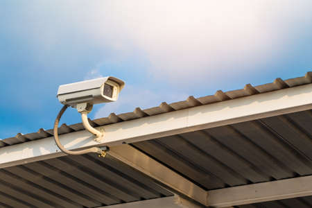 The close circuit camera on the roof with the blue sky background. The security system from the close-circuit camera.の写真素材