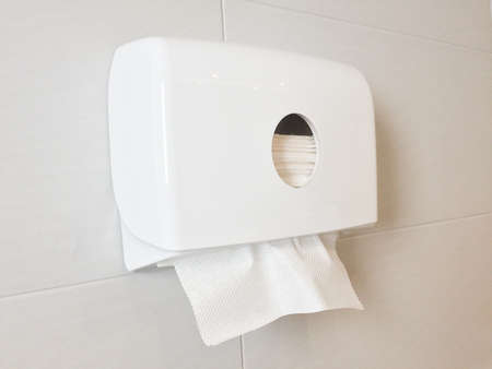 White box of tissues on wall in toilet (restroom).の写真素材