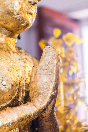 The Buddha statue to gild with gold leaf. Which people use to worship the buddha image. Selective focus.の写真素材