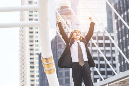 Middle-aged Engineer or architect woman in winner and success in business. Middle-aged women professional winner standing in central of city.の写真素材