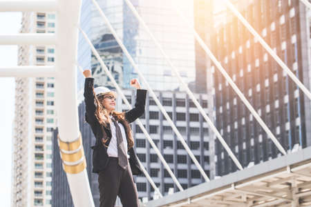 Middle-aged Engineer or architect woman in winner and success in bussiness. Middle-aged women professional winner standing in central of city.の写真素材