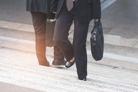 Businessman and Business woman up the stairs in a rush hour to work.の写真素材