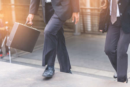 Businessman and Business woman up the stairs in a rush hour to work.の写真素材