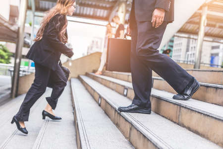 Businessman and Business woman up the stairs in a rush hour to work.の写真素材