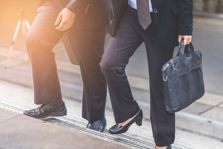Businessman and Business woman up the stairs in a rush hour to work.の写真素材