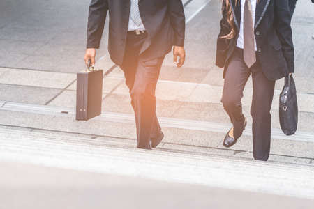 Businessman and Business woman up the stairs in a rush hour to work.の写真素材