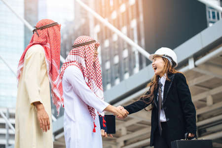 Business success concept. Asian muslim businessman and Engineer woman making handshake or holding hand together to agree joint business and partnership.の写真素材