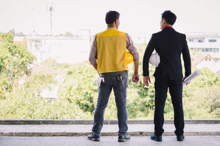 Labor and engineer standing with safety helmet on old buildings in their job site.の写真素材