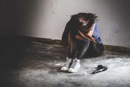 Sad women who are thinking about suicide committed by guns. Social problems concept.の写真素材