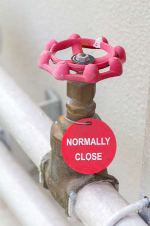 The water valve at the connection steel pipe steel wih normaly close label and water piping system. Manual valve. Old brass valve.の写真素材