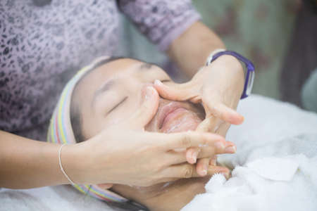 Young woman getting Spa Face Massage with hot stream. Facial Beauty Treatment in Spa Salon.の写真素材