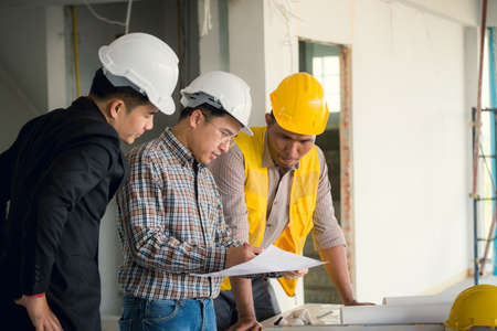 Management consulting and engineers and foreman working with blueprint and drawing on work table for management business plan and construction site project.の写真素材