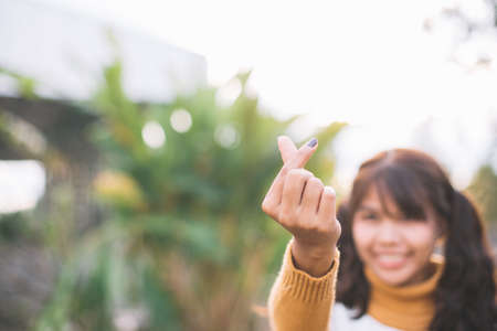 Small Heart shape made with young women in  green natural background. Love symbol concept.の写真素材
