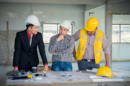 Management consulting and engineers and foreman working with blueprint and drawing on work table for management business plan and construction site project.の写真素材