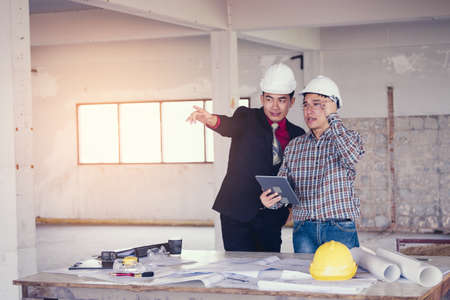 Management consulting and engineers working with tablet and drawing on work table in for management business plan and construction site project.の写真素材