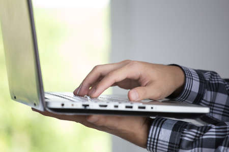 computer hacker of terrorist stealing information with laptop in abandoned building. Low key photo.の写真素材