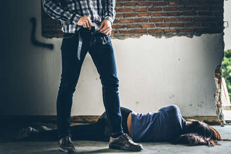 Sexual abuse with a terrorist attacking a scared woman in a dark place. Rape and Sexual abuse concept.の写真素材