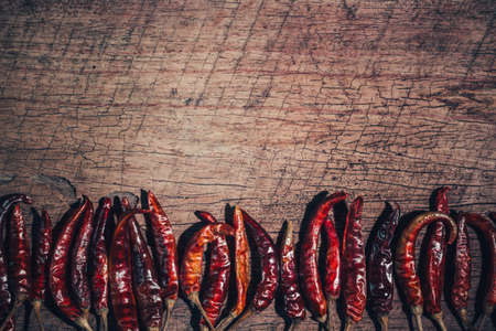 Dried red chilli pepper on wood background. Top viewの写真素材