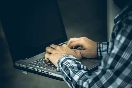 computer hacker of terrorist stealing information with laptop in abandoned building. Low key photo.の写真素材
