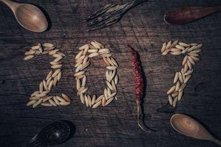 Paddy was arranged word to 2017 A.D. with wooden spoon and fork and chilli on old wooden background. For Happy New Year 2017 concept. on old wooden background. For Happy New Year 2017 concept.の写真素材