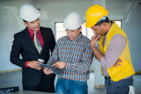 Management consulting and engineers and foreman working with blueprint and drawing on work table for management business plan and construction site project.の写真素材