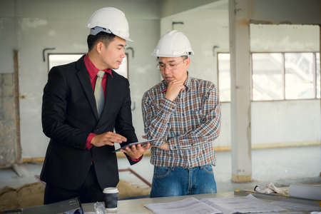 Management consulting and engineers and foreman working with blueprint and drawing on work table for management business plan and construction site project.の写真素材