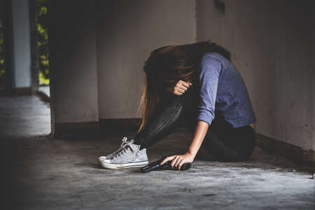 Sad women who are thinking about suicide committed by guns. Social problems concept.の写真素材