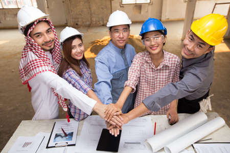 Harmonious Muslim engineer and technician team meeting in building construction site. Stacking...