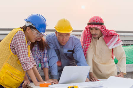 Harmonious Muslim engineer and technician team meeting in building construction site. Stacking hands. Teamwork collaboration relation conceptの写真素材