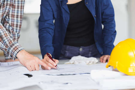 Management consulting or Engineer and labor woman working with blueprint and drawing on work table in for management business plan and construction site project.の写真素材