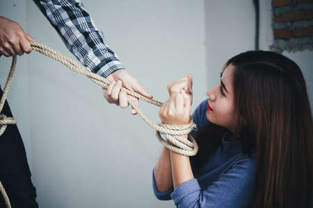 Sexual abuse with a terrorist attacking a scared woman in a dark place. Rape and Sexual abuse concept.の写真素材