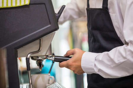 Barista holding portafilter with ground coffee in cafe for prepare to make espresso coffee.の写真素材